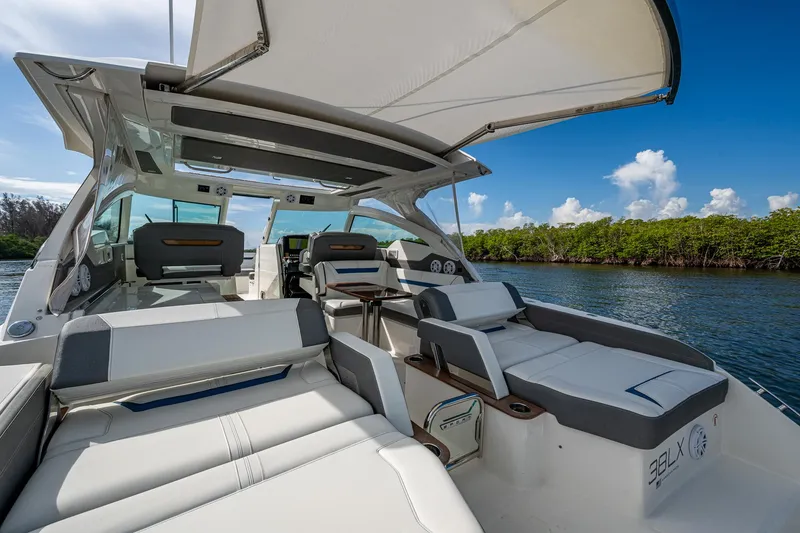 Slide: The Image of Luxurious 2021 Tiara Yachts 38 LX with spacious seating and canopy on a serene waterway. - 39