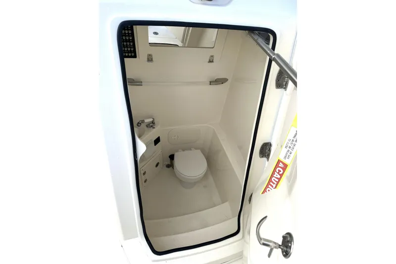 Slide: The Image of 2023 Cobia 240 Center Console boat interior with compact marine toilet. - 24