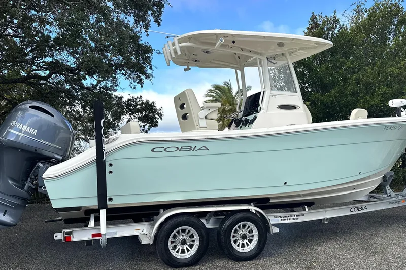 Slide: The Image of 2023 Cobia 240 Center Console boat on trailer with Yamaha engine, parked outdoors. - 3