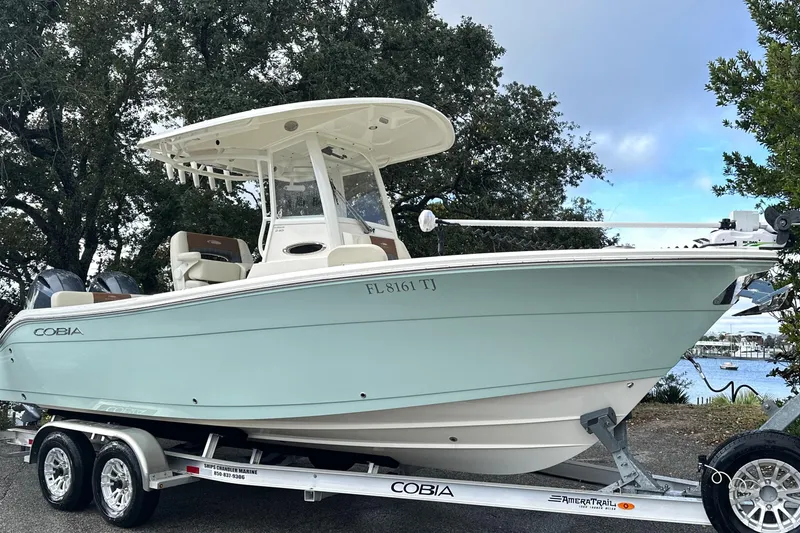 Slide: The Image of 2023 Cobia 240 Center Console boat on trailer, parked near waterfront. - 4