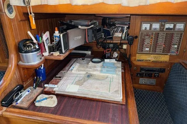Slide: The Image of Navigation station on a 1982 Formosa 42 sailboat with charts and equipment. - 10