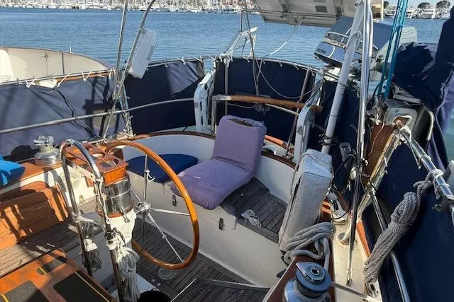 Slide: The Image of 1982 Formosa 42 sailboat cockpit with wooden wheel, blue covers, and marina view. - 15