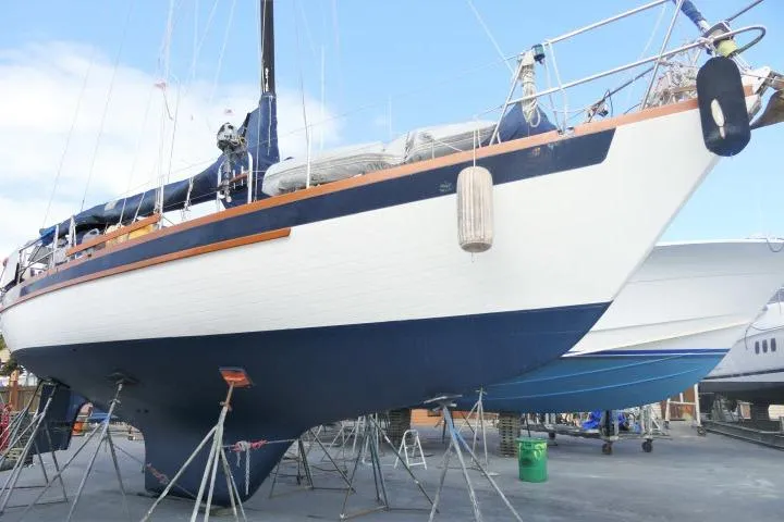 Slide: The Image of 1982 Formosa 42 sailboat on stands, blue and white hull, outdoor setting. - 20