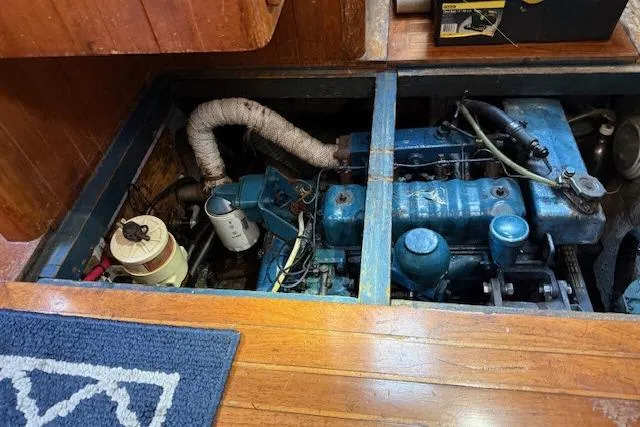 Slide: The Image of 1982 Formosa 42 engine compartment with visible blue engine and wooden flooring. - 24