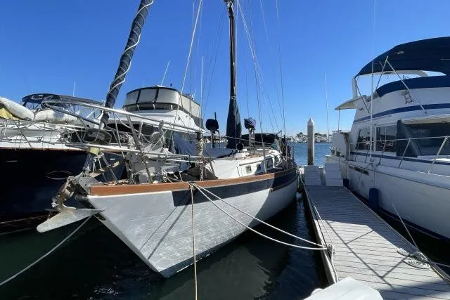 Slide: The Image of 1982 Formosa 42 sailboat docked at marina under clear blue sky. - 29