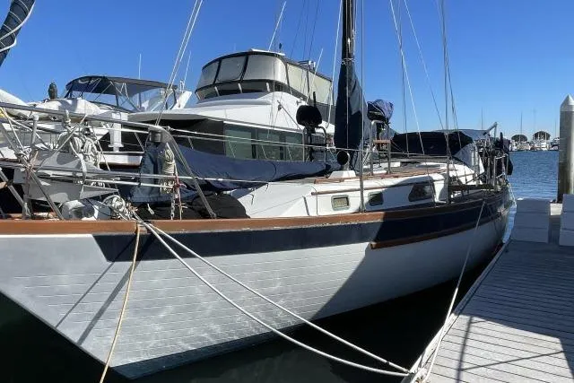 Slide: The Image of 1982 Formosa 42 sailboat docked at marina under clear blue sky. - 30