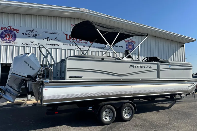 Slide: The Image of 2026 Premier 250 SunSation RF pontoon boat with Mercury engine, parked outside dealership. - 8