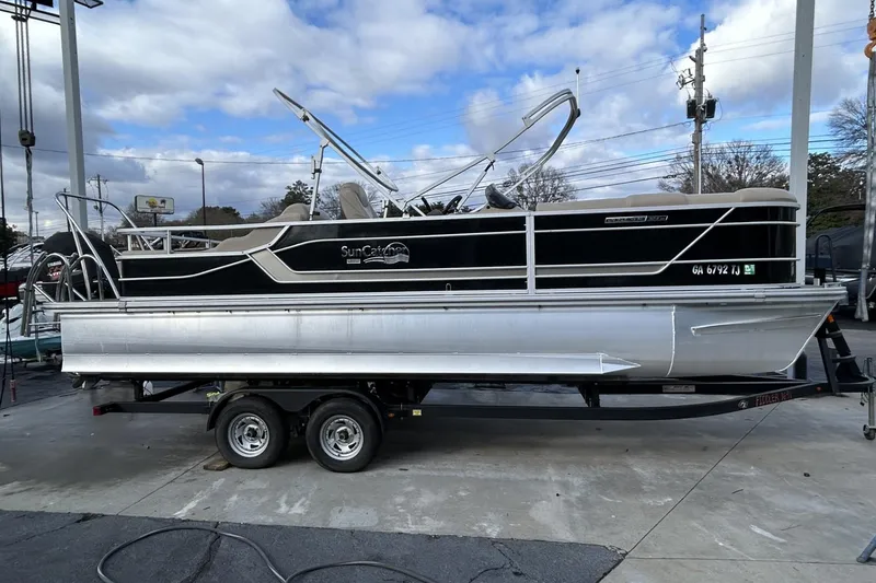 The Image of 2022 SunCatcher Fusion 324SS pontoon boat on trailer, parked outdoors. - 0