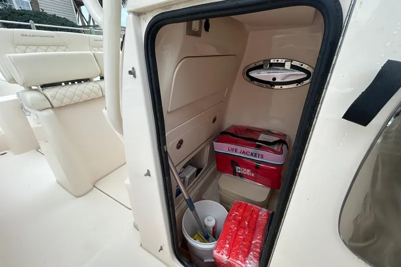 Slide: The Image of 2025 Grady-White Fisherman 236 boat interior storage with life jackets and cleaning supplies. - 25