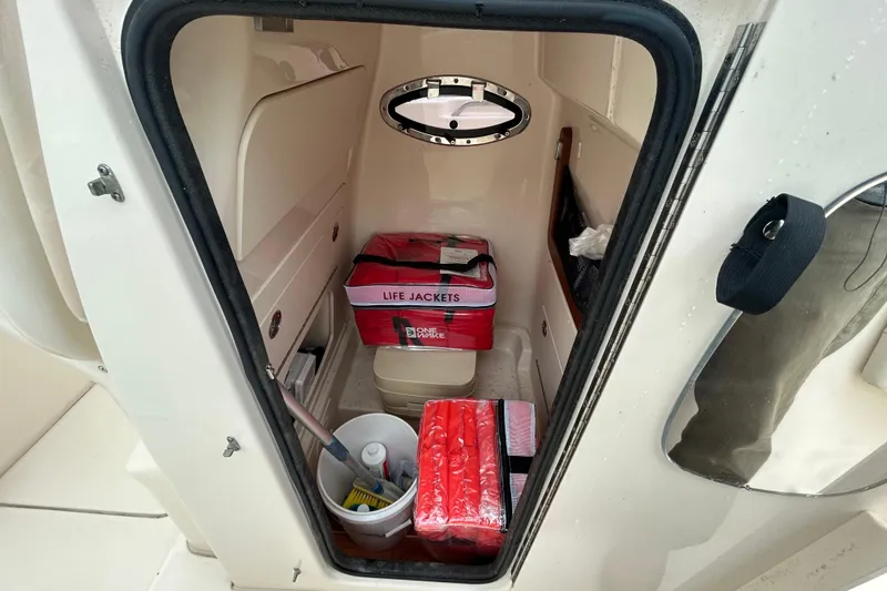 Slide: The Image of Interior of 2025 Grady-White Fisherman 236 boat with life jackets and cleaning supplies. - 26