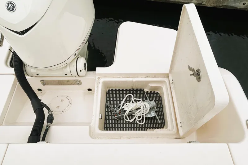 Slide: The Image of 2025 Grady-White Fisherman 236 boat with open storage compartment and engine detail. - 5
