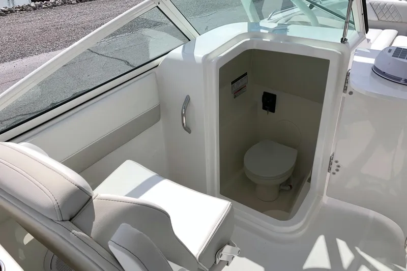 Slide: The Image of Interior of 2026 World Cat 230 SD boat featuring a compact marine toilet. - 14