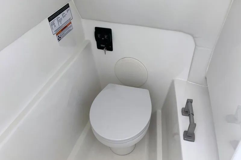 Slide: The Image of Interior of 2026 World Cat 230 SD boat featuring a compact marine toilet. - 15