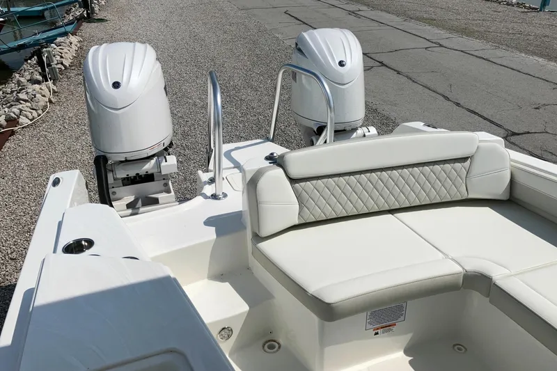 Slide: The Image of 2026 World Cat 230 SD boat with dual engines and white seating, docked on gravel. - 4