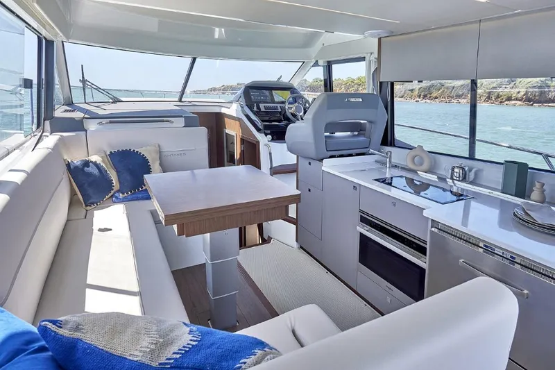 Slide: The Image of Luxurious interior of 2026 Beneteau Antares 12 Fly OB yacht with modern kitchen and seating. - 9