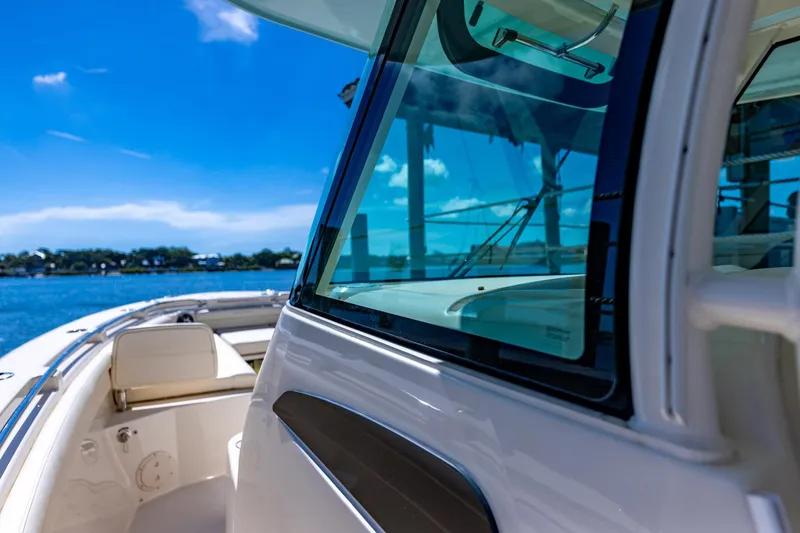 Slide: The Image of 2022 Grady-White Canyon 336 boat on a sunny day, docked by the water. - 15