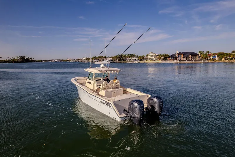 Slide: The Image of 2022 Grady-White Canyon 336 boat cruising on a sunny day near waterfront homes. - 46