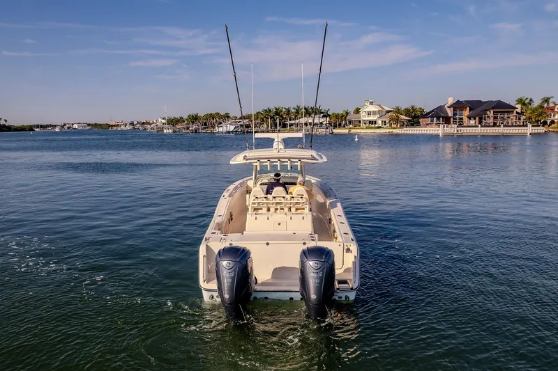 Slide: The Image of 2022 Grady-White Canyon 336 boat on calm water near waterfront homes. - 47