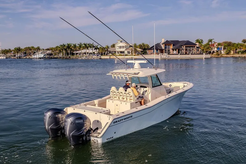 Slide: The Image of 2022 Grady-White Canyon 336 boat cruising on a calm waterfront with scenic background. - 48