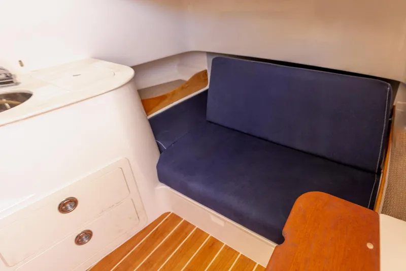 Slide: The Image of 2022 Grady-White Canyon 336 cabin interior with blue seating and wooden flooring. - 7