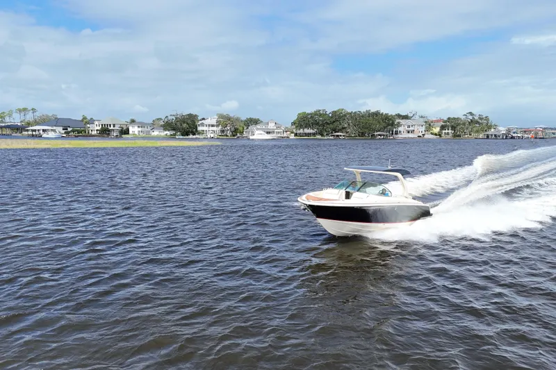 Slide: The Image of 2020 Chris-Craft Launch 31 GT speeding on a scenic lake with waterfront homes. - 14