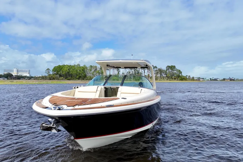 Slide: The Image of 2020 Chris-Craft Launch 31 GT boat on water, clear sky background. - 16