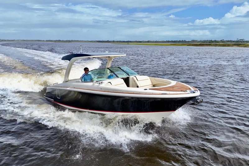 Slide: The Image of 2020 Chris-Craft Launch 31 GT cruising on open water under a clear sky. - 2