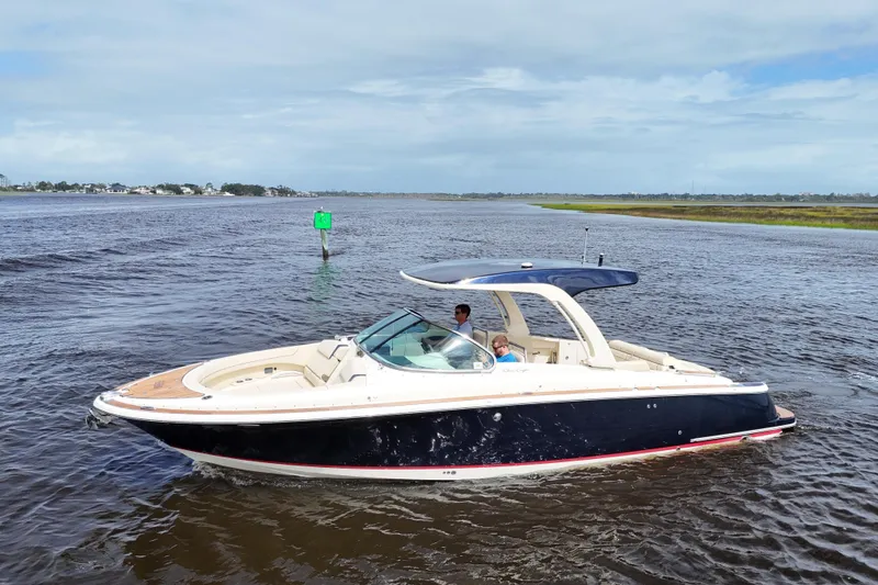 Slide: The Image of 2020 Chris-Craft Launch 31 GT boat cruising on open water under a clear sky. - 20