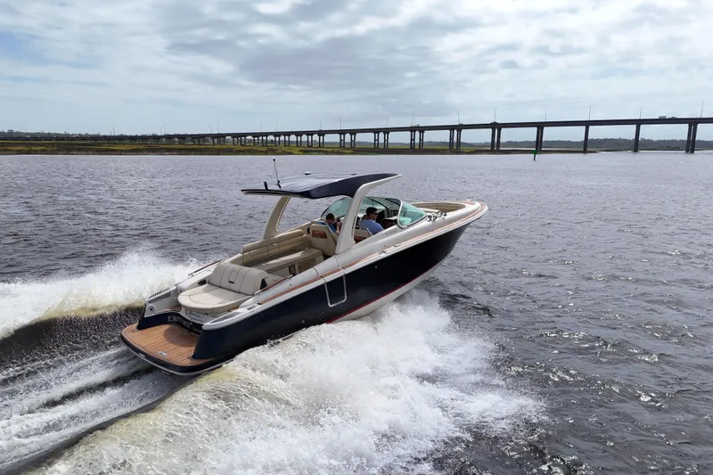 Slide: The Image of 2020 Chris-Craft Launch 31 GT cruising on open water near a bridge. - 3