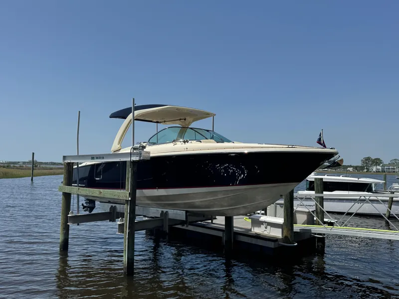 Slide: The Image of 2020 Chris-Craft Launch 31 GT boat on lift, docked in sunny marina. - 31