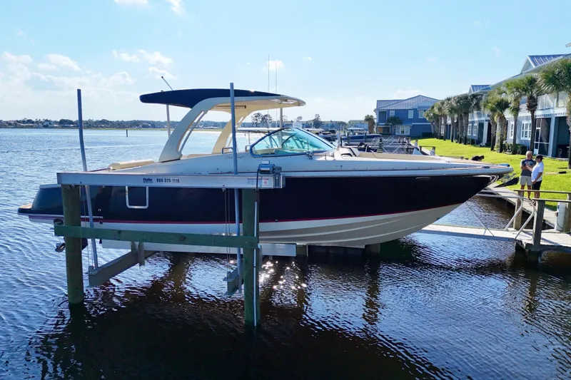 Slide: The Image of 2020 Chris-Craft Launch 31 GT boat docked by waterfront homes. - 33