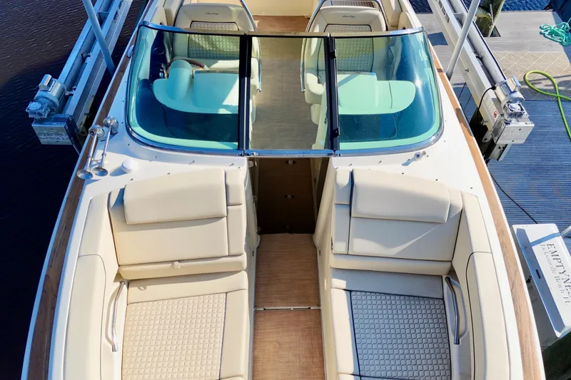 Slide: The Image of 2020 Chris-Craft Launch 31 GT boat interior with beige seating and glass windshield. - 42