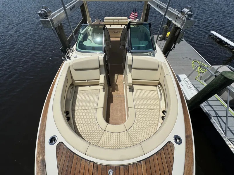 Slide: The Image of 2020 Chris-Craft Launch 31 GT boat with elegant seating and wooden deck, docked by the water. - 43