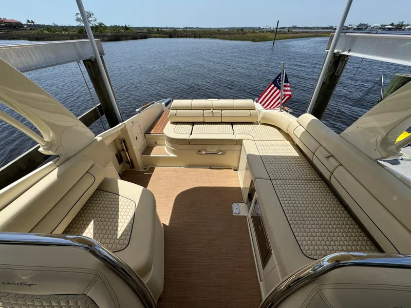 Slide: The Image of 2020 Chris-Craft Launch 31 GT boat interior with beige seating and American flag. - 65