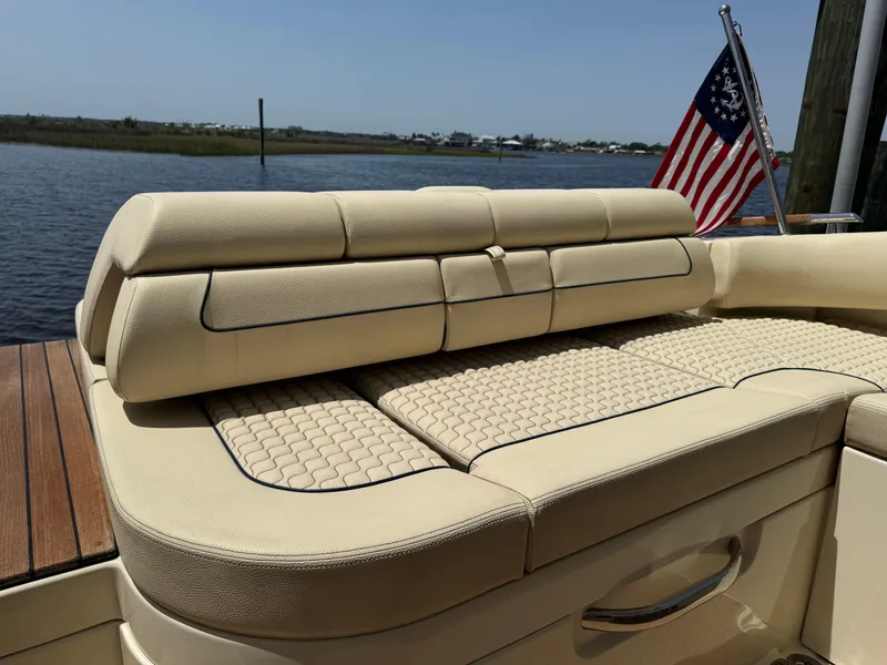 Slide: The Image of 2020 Chris-Craft Launch 31 GT boat with beige seating and American flag. - 67