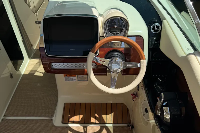 Slide: The Image of 2020 Chris-Craft Launch 31 GT dashboard with wooden steering wheel and modern controls. - 72