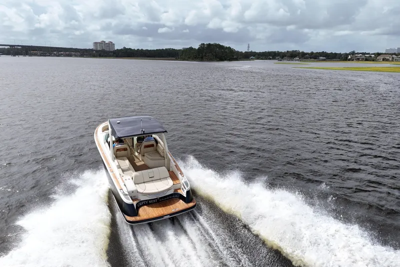 Slide: The Image of 2020 Chris-Craft Launch 31 GT cruising on a scenic lake under cloudy skies. - 8