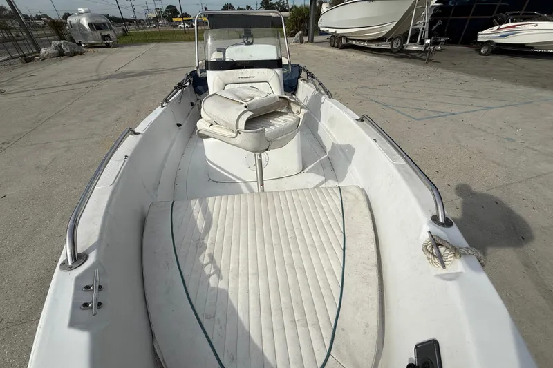 Slide: The Image of 2007 Triumph 170CC boat with white interior, parked in a marina. - 11