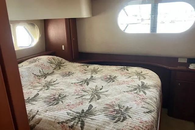 Slide: The Image of 2006 Silverton 39 Motor Yacht bedroom with floral bedding and oval windows. - 12