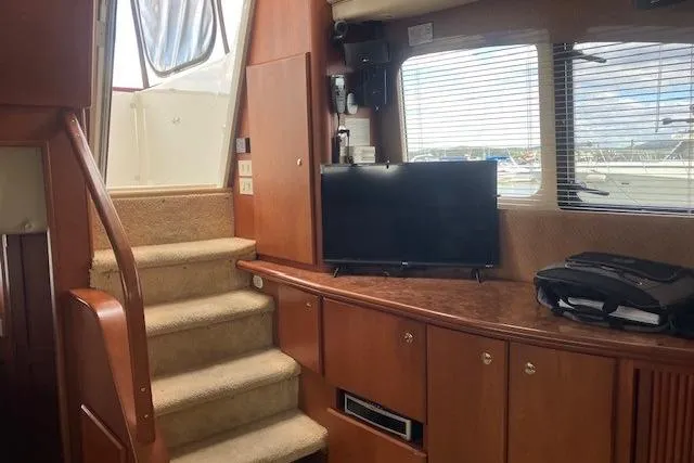 Slide: The Image of Interior of 2006 Silverton 39 Motor Yacht with stairs, TV, and window view. - 8