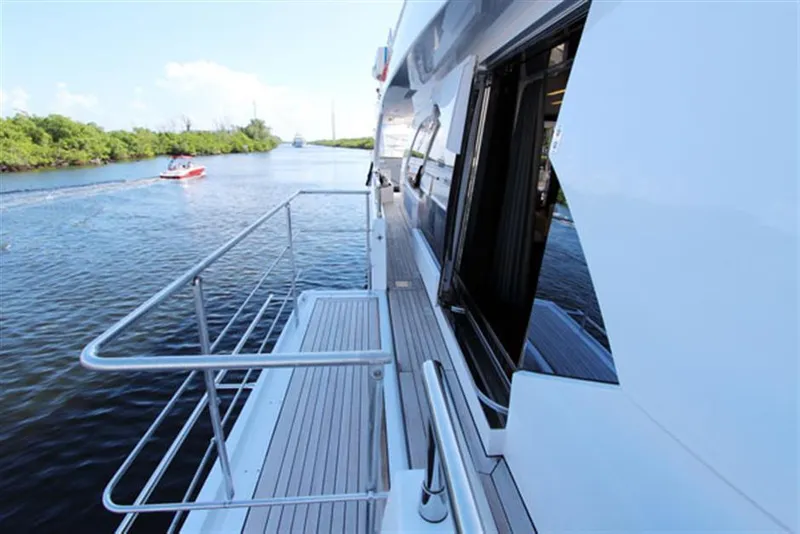 Slide: The Image of Side deck view of 2014 Azimut 100 Grande yacht cruising on a calm river. - 2