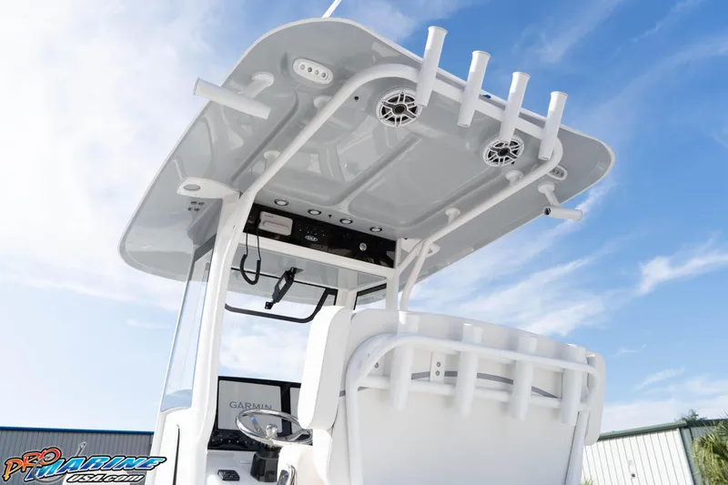 Slide: The Image of 2026 Sea Hunt Gamefish 25 boat with T-top and rod holders against blue sky. - 12