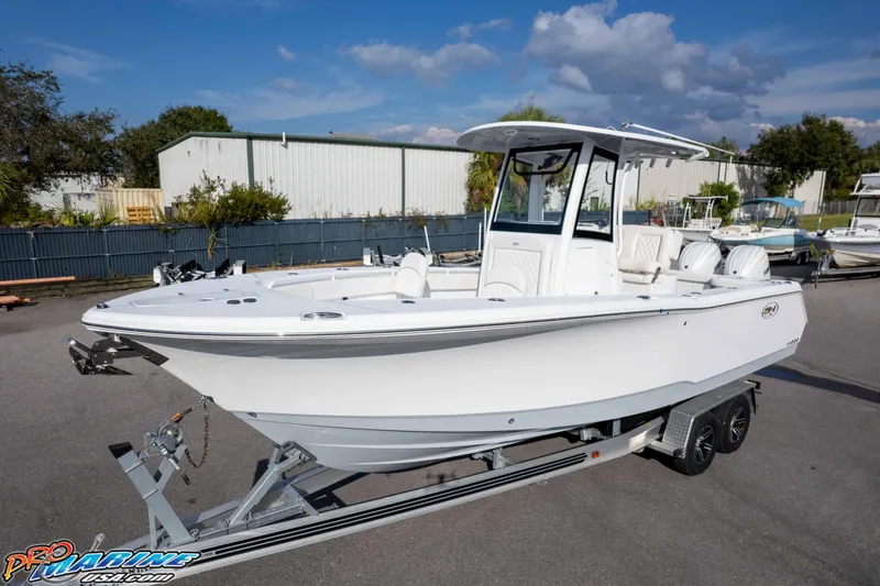 Slide: The Image of 2026 Sea Hunt Gamefish 25 boat on trailer, parked outdoors under clear sky. - 24