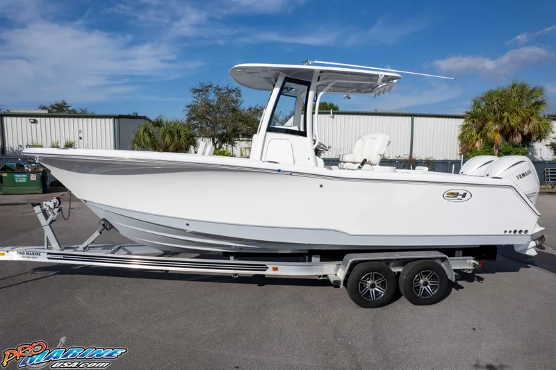 Slide: The Image of 2026 Sea Hunt Gamefish 25 boat on trailer, parked outdoors, side view. - 28