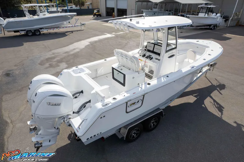 Slide: The Image of 2026 Sea Hunt Gamefish 25 boat with dual Yamaha engines, parked on a trailer. - 35