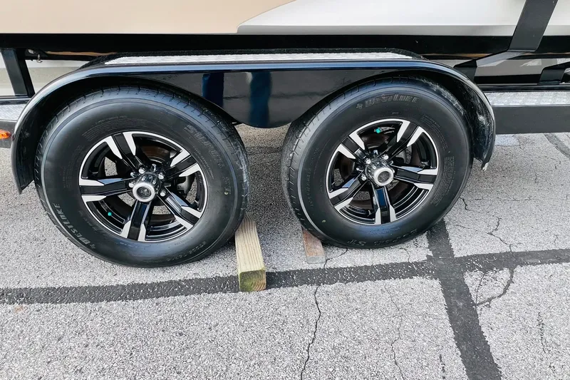 Slide: The Image of 2019 Bryant POTENZA 270 trailer wheels on pavement, featuring black alloy rims. - 86
