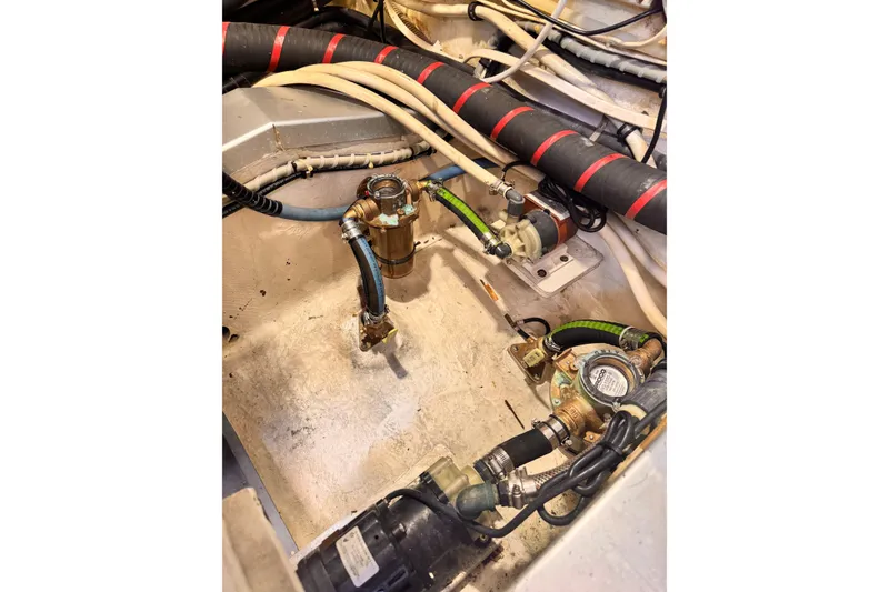 Slide: The Image of Engine room of 2000 Grand Banks East Bay 49 with hoses and valves. - 55