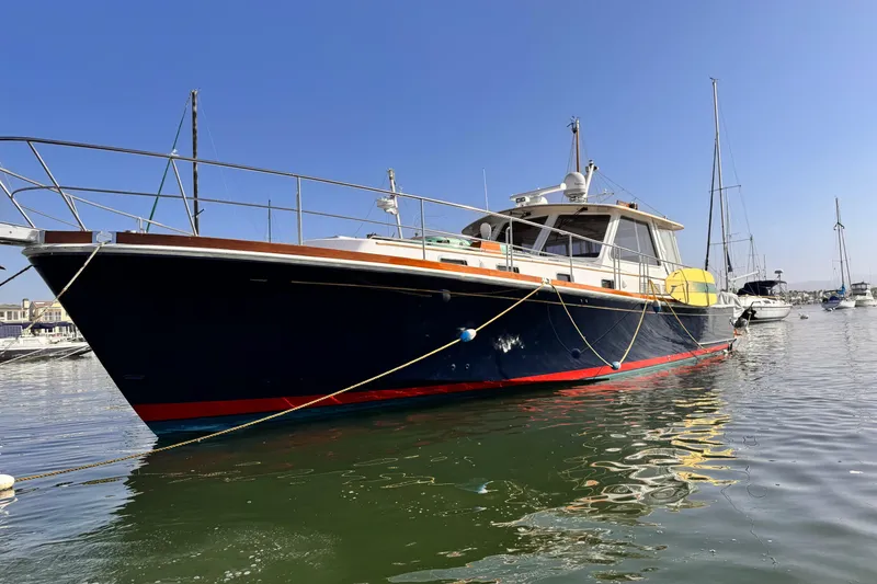 The Image of 2000 Grand Banks East Bay 49 yacht docked in a marina under clear blue skies. - 0