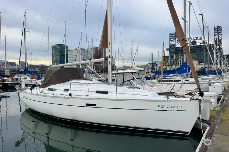 The Image of 2001 Beneteau 331 sailboat docked in a marina with cityscape background. - 0