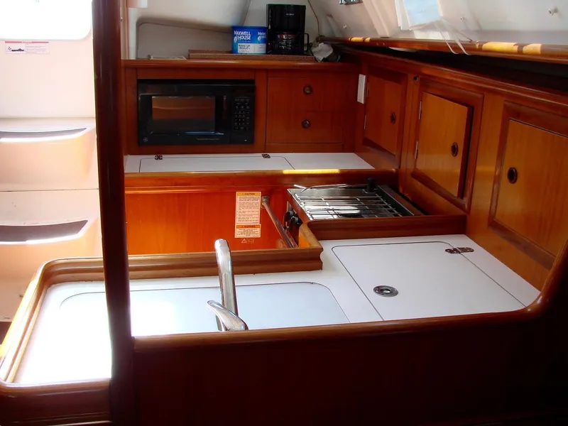 Slide: The Image of Beneteau 331 yacht kitchen, 2001 model, featuring wood cabinets and stove. - 23